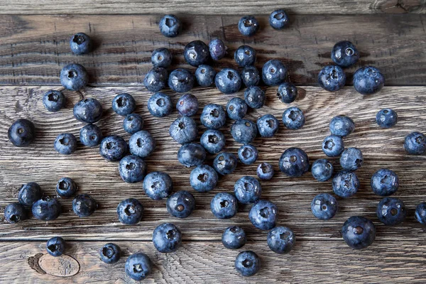 Blueberry  lie on wooden background. Rustic cozy background with healthy food. Fresh-gathered berries full of vitamins, good for diet nutrition and healthy meals.