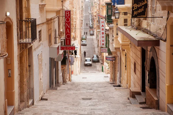 Old Battery street in Valletta, Malta. Old-fashioned street with many stairs, balcony, hotels and cafe.