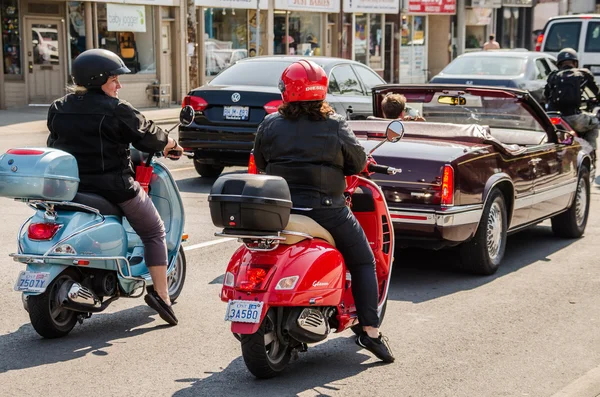 Two women on motorcycles chatting in Toronto, Canada