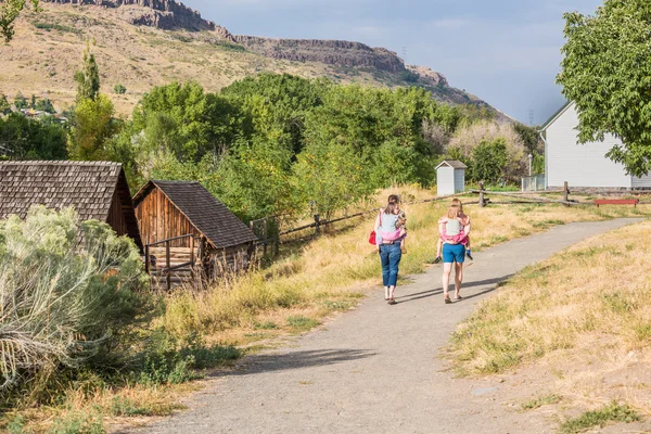 Golden, USA - September 14, 2015: Two moms with children walking on path in barn by canyons