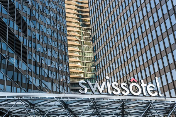 Modern urban architecture of Swissotel in downtown city with text, sign and logo and many windows
