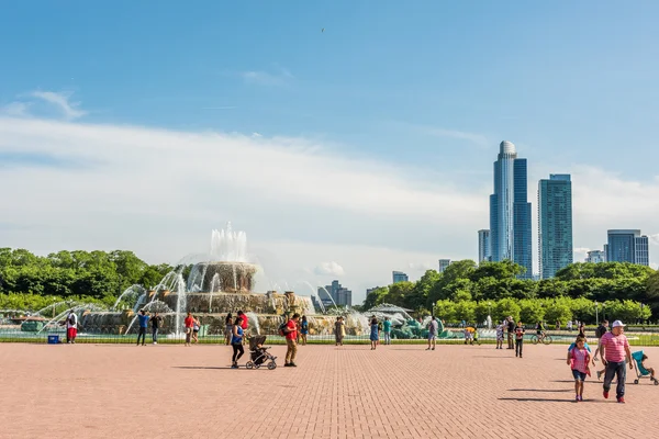 Buckingham Memorial Fountains in Grant Park in Illinois with people walking on a hot summer day with skycrapers in Chicago, USA
