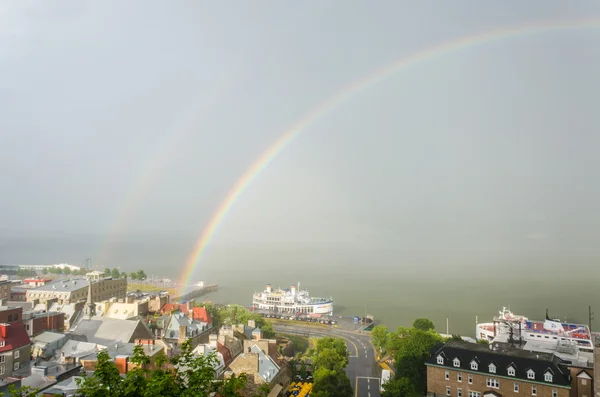 Double rainbow in downtown with view of Saint Lawrence river and boats