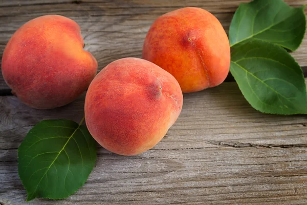 Juicy peaches on old wooden background. Selective focus