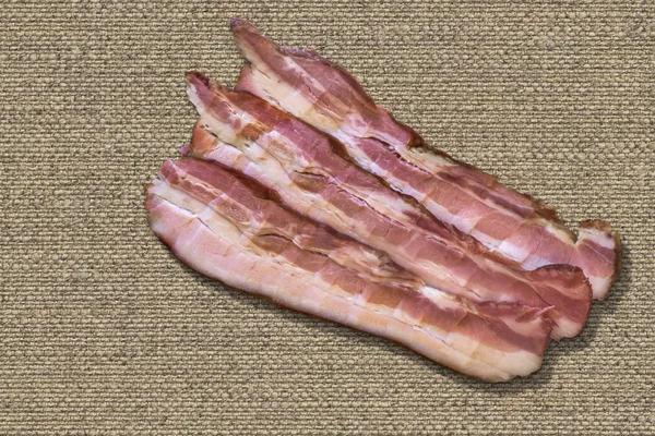 Three Belly Bacon Rashers On Natural Linen Canvas Background