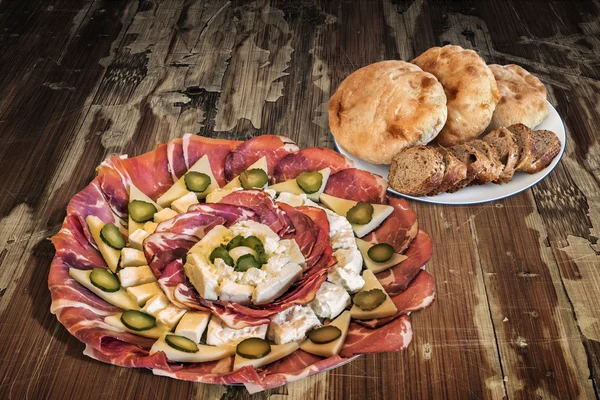 Antipasto Dish Meze with Baguette Integral Bread Slices and Pita Bread Loafs on Old Wooden Table
