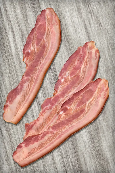 Pork Bacon Rashers on Bleached Wood Background