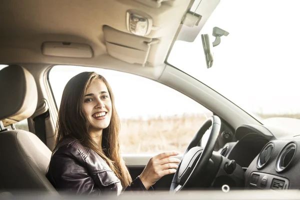 Woman in car holding steering wheel