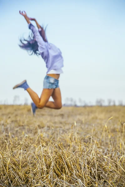 Woman jumping in agriculture field.
