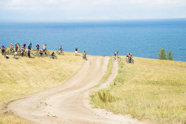 Bicyclists on hill of mountain above Baikal lake