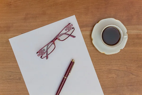 Paper, pen, glasses and coffee