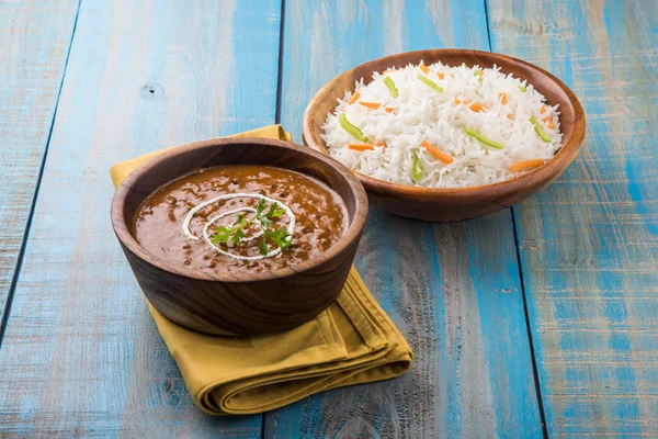 Dal Makhani or daal makhni or Daal makhani, indian lunch/dinner item served with plain rice and butter Roti, Chapati, Paratha and salad, over blue wooden table top