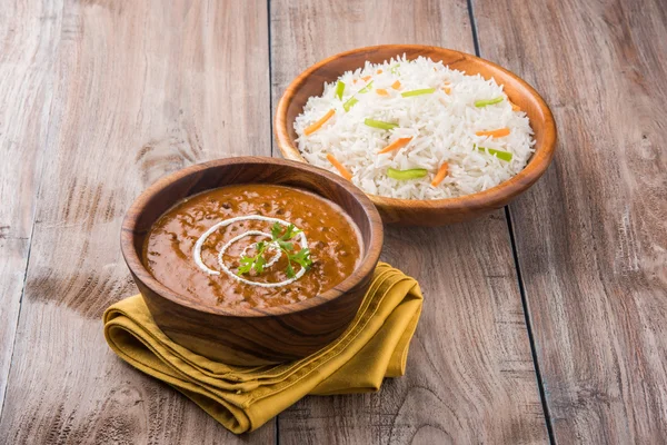 Dal Makhani or daal makhni or Daal makhani, indian lunch/dinner item served with plain rice and butter Roti, Chapati, Paratha and salad, over blue wooden table top