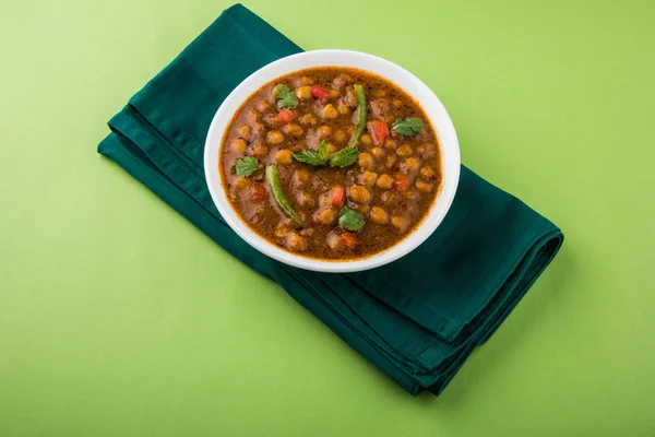 Indian dish spicy Chick Peas also known as Chola Masala or Chana Masala or Chole served in a white bowl, isolated