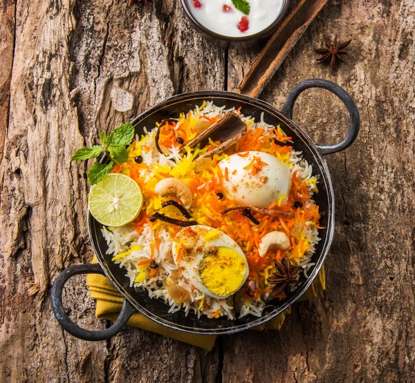 Basmati rice slowly cooked with Masala roasted egg and spices served in kadhai or kadai with yogurt dip, selective focus, egg biryani or anda rice or egg rice