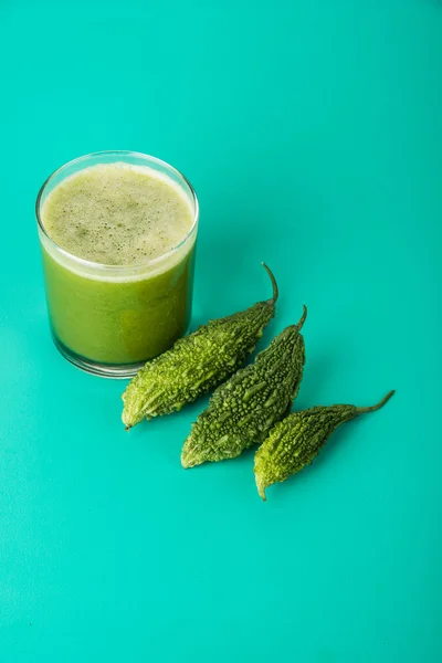 Herbal juice of green momodica in a glass with sliced vegetables, karela juice or bitter gourd juice