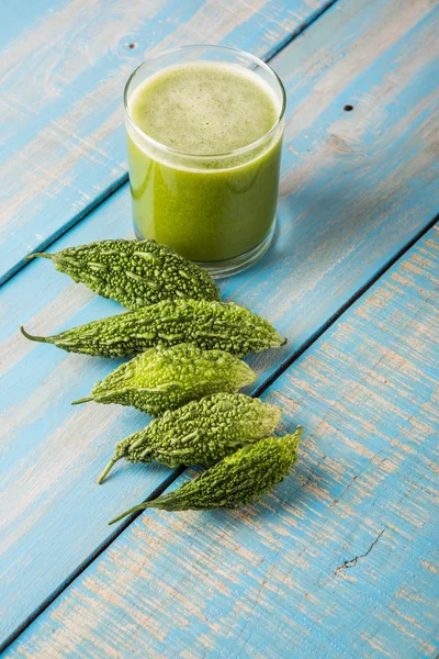 Herbal juice of green momodica in a glass with sliced vegetables, karela juice or bitter gourd juice