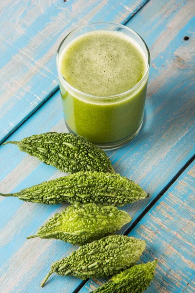 Herbal juice of green momodica in a glass with sliced vegetables, karela juice or bitter gourd juice