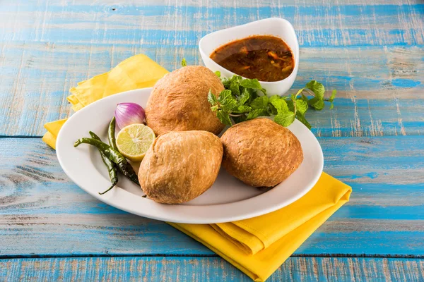 Kachori or Kachauri or Kachodi or Katchuri is a spicy snack popular in various parts India, pakistan. with green salad, pudina chutney and tea in white crockery