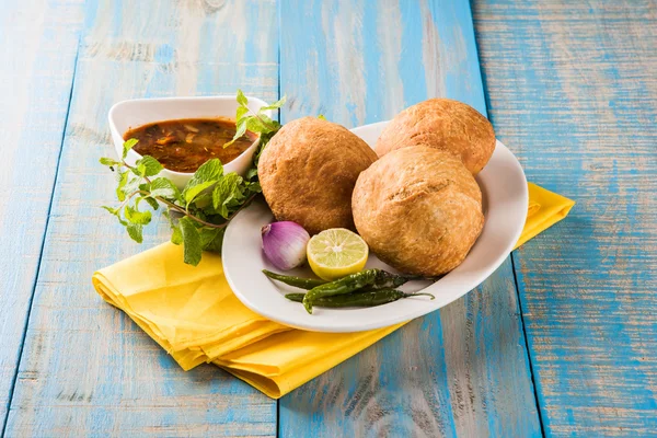 Kachori or Kachauri or Kachodi or Katchuri is a spicy snack popular in various parts India, pakistan. with green salad, pudina chutney and tea in white crockery