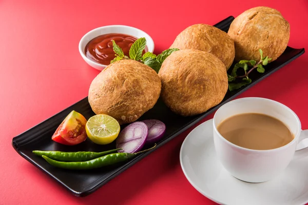 Kachori or Kachauri or Kachodi or Katchuri is a spicy snack popular in various parts India, pakistan. with green salad, pudina chutney and tea in white crockery