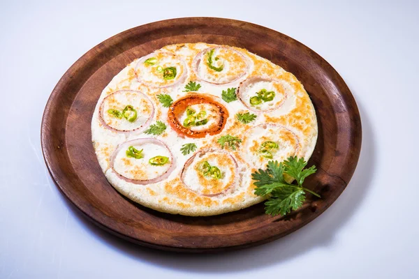 South indian food, two uttapam with coconut chutney in white ceramic plate with coriander leaf, closeup and front view, isolated on white background