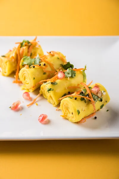 Khandvi is a gujarati snack from India which is made with gram flour and curds tempered with sesame seeds and mustard seeds also known as Surali chya Vadya/Stuffed Khandvi, selective focus