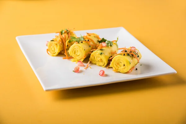 Khandvi is a gujarati snack from India which is made with gram flour and curds tempered with sesame seeds and mustard seeds also known as Surali chya Vadya/Stuffed Khandvi, selective focus