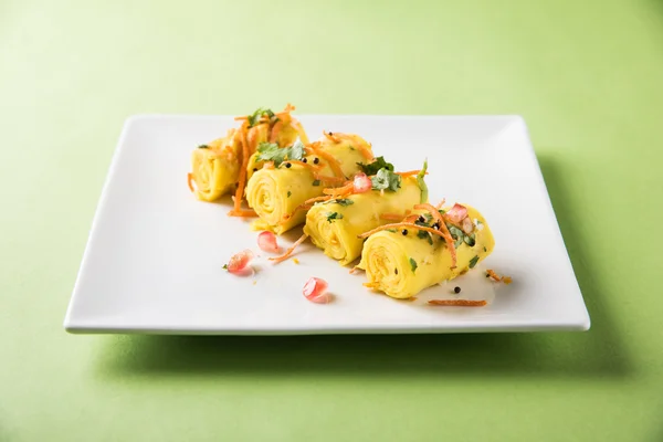 Khandvi is a gujarati snack from India which is made with gram flour and curds tempered with sesame seeds and mustard seeds also known as Surali chya Vadya/Stuffed Khandvi, selective focus