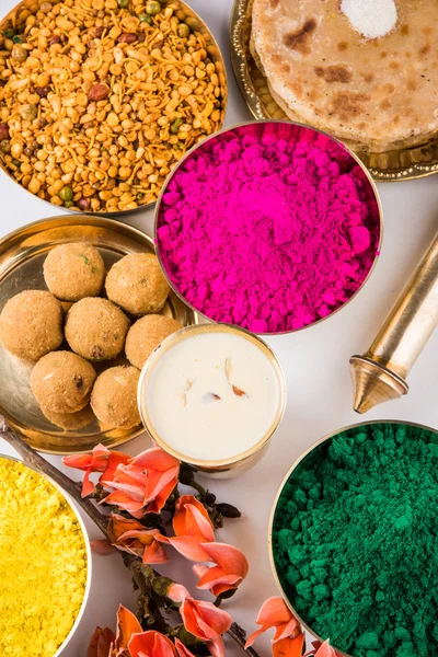 Holi festival food with colours, indian festival holi, samosa, kachori, laddu, gujiya, palash flower, thandai, farsan, puran poli or roti, indian festival of colours called holi