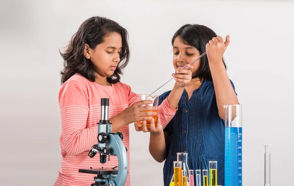 Curious indian girls with microscope, asian girls with microscope, Cute little girls holding microscope, 10 year old indian girls and science experiment, girls doing science experiments, science lab