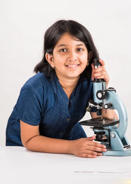 Curious indian girl with microscope, asian girl with microscope, Cute little girl holding microscope, 10 year old indian girl and science experiment, girl doing science experiments, science lab