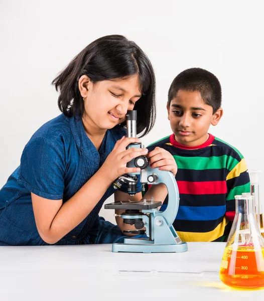 Indian small boy and girl doing science experiment, science Education. asian kids and science experiments, chemistry experiment, indian kids and science experiments, indian kids and science lab