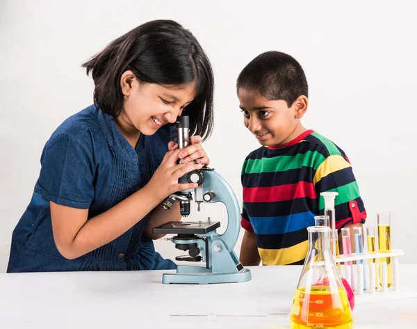 Indian small boy and girl doing science experiment, science Education. asian kids and science experiments, chemistry experiment, indian kids and science experiments, indian kids and science lab