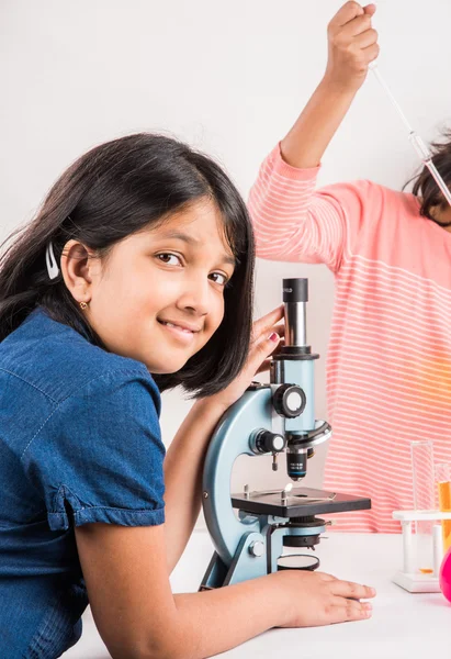 Curious indian girls with microscope, asian girls with microscope, Cute little girls holding microscope, 10 year old indian girls and science experiment, girls doing science experiments, science lab