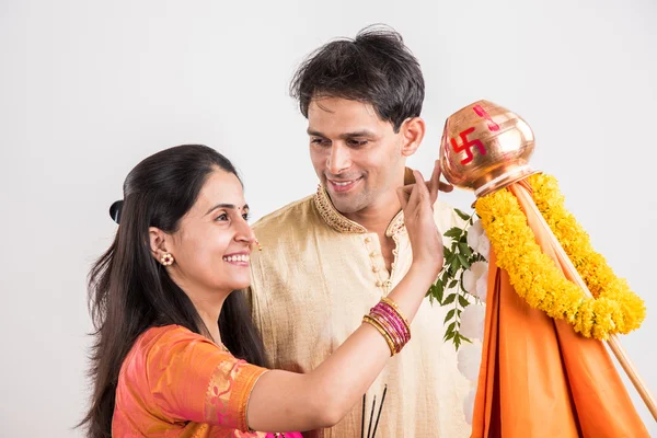 Smart indian couple in traditional wear performing gudhi padwa puja, asian couple & puja thali, indian young couple with puja or pooja thali, hindu new year gudhi / gudi padwa, isolated