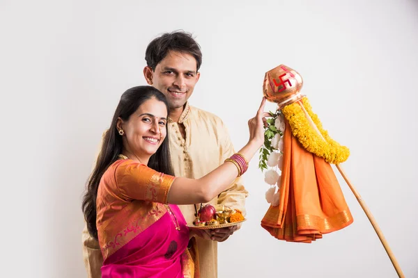 Smart indian couple in traditional wear performing gudhi padwa puja, asian couple & puja thali, indian young couple with puja or pooja thali, hindu new year gudhi / gudi padwa, isolated