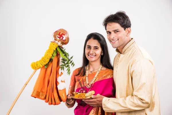 Smart indian couple in traditional wear performing gudhi padwa puja, asian couple & puja thali, indian young couple with puja or pooja thali, hindu new year gudhi / gudi padwa, isolated