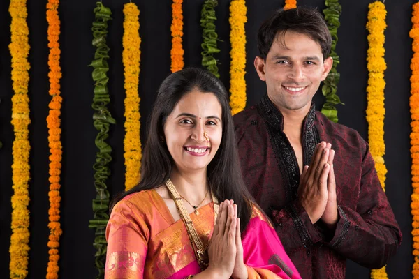 Portrait of Maharashtrian couple holding a puja thali, indian couple holding puja thali or pooja thali, indian couple celebrating diwali, laxmi pujan, asian couple and puja thali, couple doing prayer