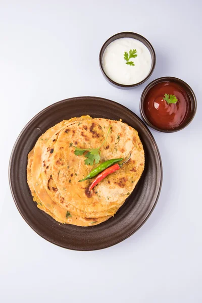 Traditional Indian bread - Aloo paratha or aalu parotha, potato stuffed bread. served with tomato ketchup or sauce and curd