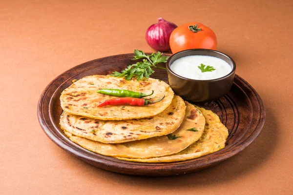 Traditional Indian bread - Aloo paratha or aalu parotha, potato stuffed bread. served with tomato ketchup or sauce and curd