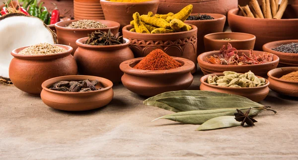 Indian spices in terracotta pots, indian colourful spices, group of indian spices, group of spices, india and spices arranged in different size terracotta pots