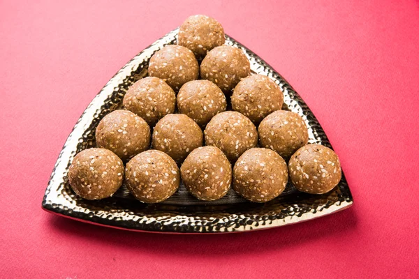 The indian sesame sweet or tilgul laddu or til gul laddu, made up of jaggery and sesame seeds, hand made, round, indian sweet prepared in Makar Sankranti festival