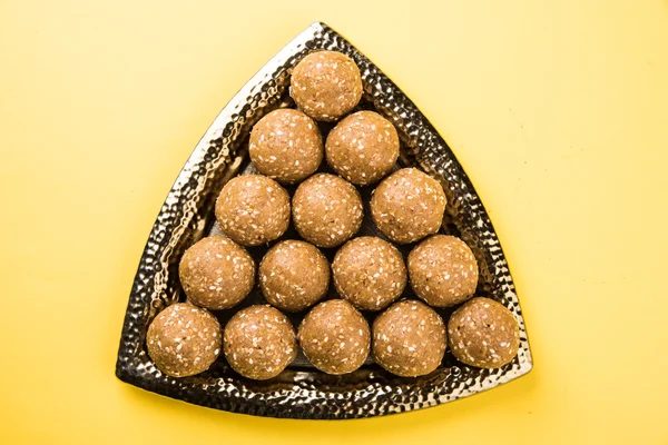 The indian sesame sweet or tilgul laddu or til gul laddu, made up of jaggery and sesame seeds, hand made, round, indian sweet prepared in Makar Sankranti festival
