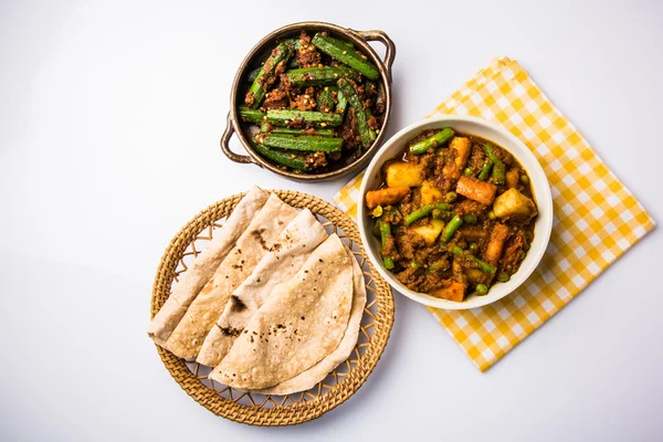 Bhindi masala or bhendi masala or ladies finger fry with mixed veg in red curry with indian roti / chapati / fulka / paratha / indian bread, indian spicy food