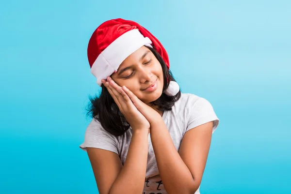 Small cute indian girl with christmas hat, thinking, indian girl and christmas, christmas and india, indian kids and christmas, indian kids celebrating christmas, asian girl and christmas, thinking