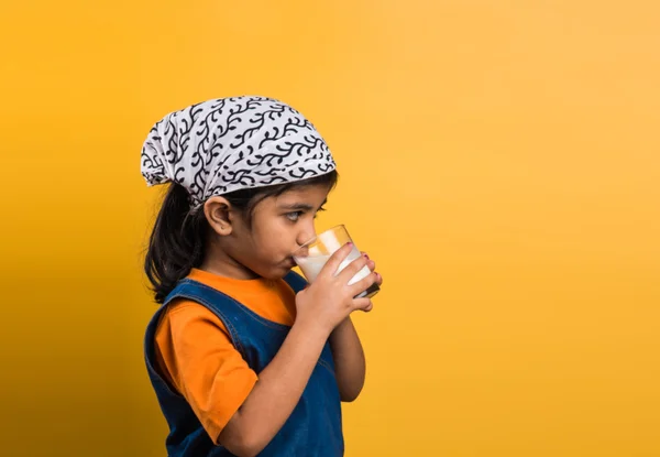 4 year old indian girl with a glass full of plain white milk, indian girl and plain milk, indian girl drinking milk, asian girl and milk glass, portrait, brown skin, indian baby girl