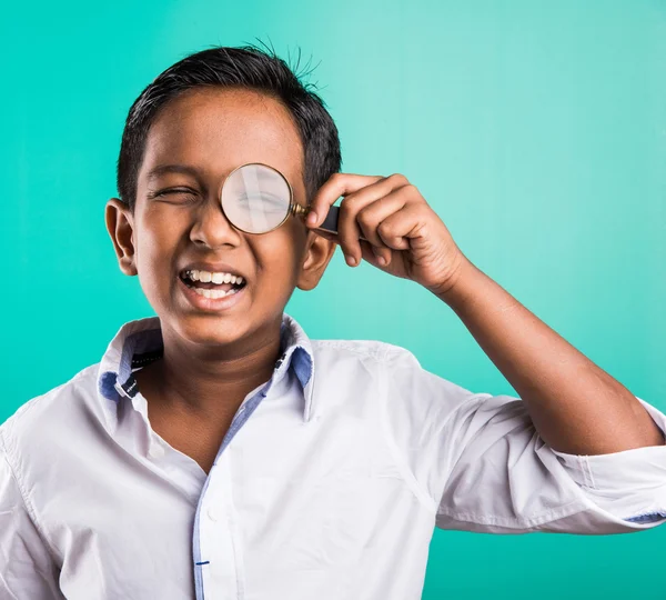 Happy indian kid with magnifying glass, asian boy looking through magnifying glass with smile, indian Boy holding a magnifying glass, indian or asian boy playing or posing with magnifying glass