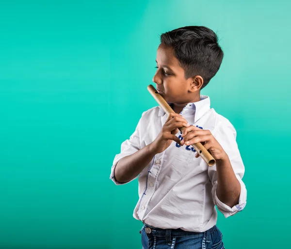 10 year old indian boy playing flute, indian boy and music, indian boy learning music, indian boy with musical instrument, brown indian boy