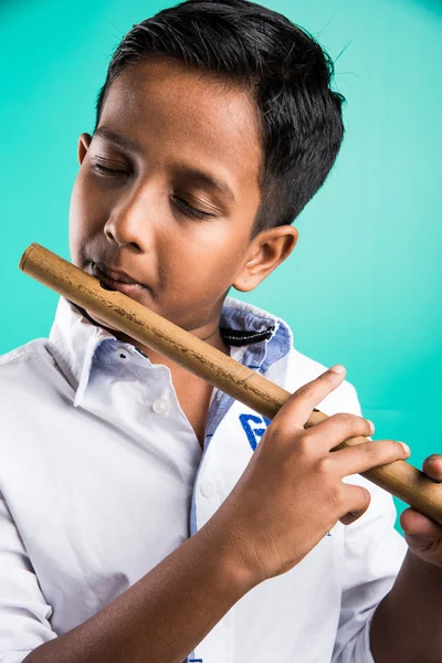 10 year old indian boy playing flute, indian boy and music, indian boy learning music, indian boy with musical instrument, brown indian boy